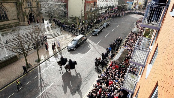 Crowds are shown packed in around Preston Minster as Sir Tom's funeral cortege arrives
