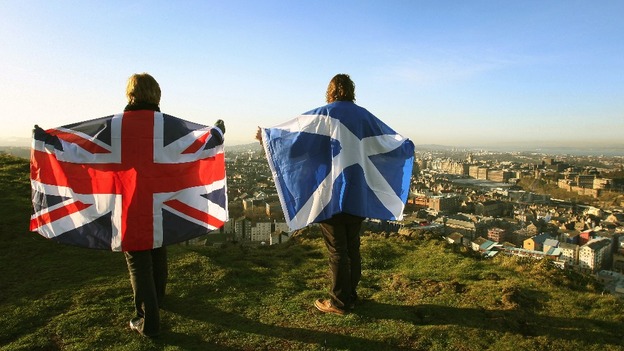 Scottish and British flags held up over Edinburgh, Scotland