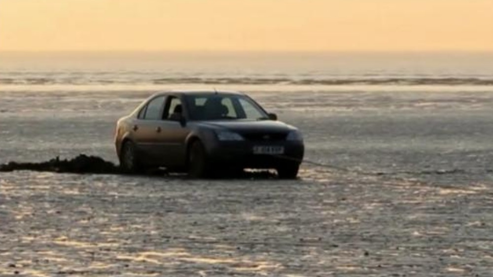 Family have to be rescued from beach after car gets stuck in soft sand ITV News