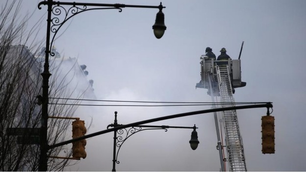 Firefighters on Park Avenue pour water on the building