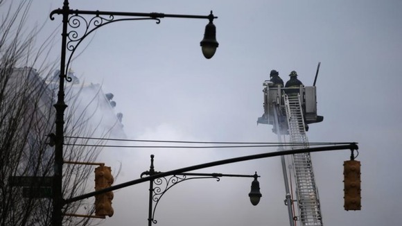 Firefighters on Park Avenue pour water on the building