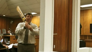 Forensic expert Johannes Vermeulen swings at a door with a cricket bat in court.