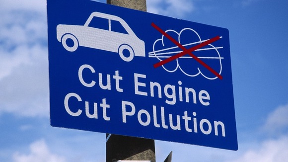 Sign asking motorists to switch of engines at railway level crossing.