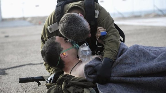 An Israeli army officer listens to a soldier who was wounded during the attack.