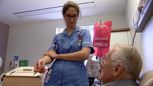 Nurse tending to old male patient