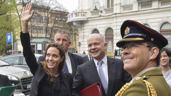Angelina Jolie waves to the crowds with Foreign Secretary William Hague in Sarajevo, Bosnia.