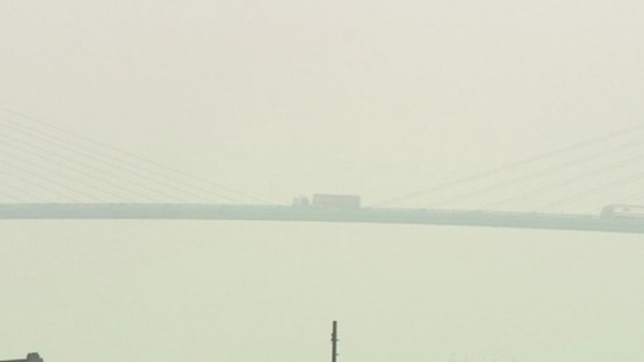A lorry is barely visible as it travels across the QEII Bridge in Essex.
