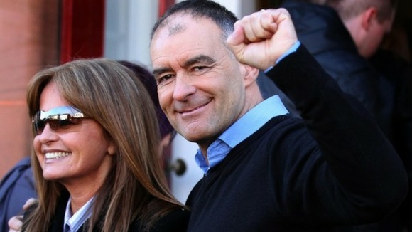 Tommy Sheridan accompanied by his wife Gail, salutes well wishers as he arrives home in Glasgow after leaving prison.