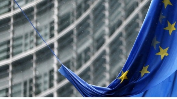 An EU flag hangs outside the European Commission headquarters in Brussels
