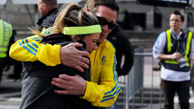 A runner at the Boston Marathon last year is comforted after the explosions.