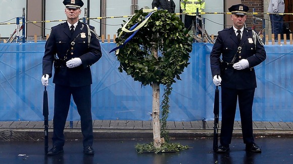Honour guards stand beside a wreath at the site of the other Boston Marathon bomb blast.
