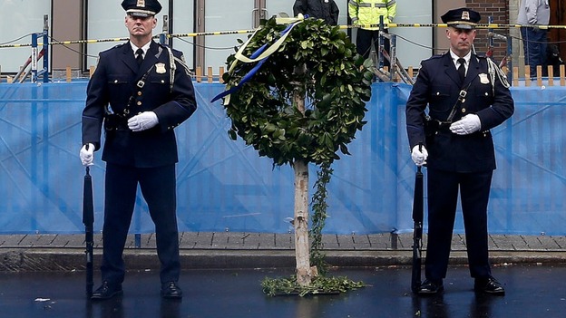 Honour guards stand beside a wreath at the site of the other Boston Marathon bomb blast.