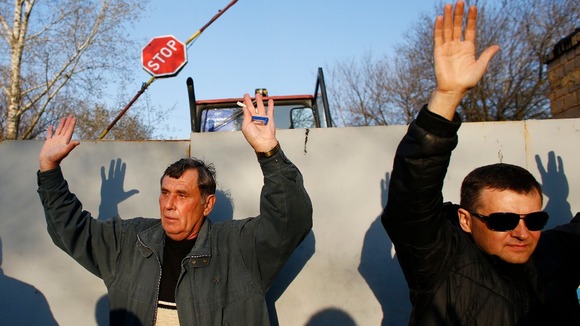 Pro-Russia separatists hold their hands up in front of the Kramatorsk airbase.