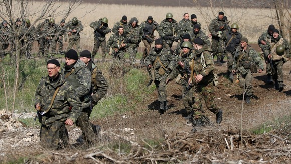 Ukrainian soldiers walk in the field near Kramatorsk where they retook an airfield from pro-Russian separatists yesterday.