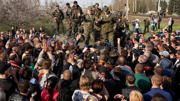 Ukrainian soldiers standing on a combat vehicle try to negotiate with pro-Russian protesters in Kramatorsk.