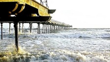 tide crashing against pier and beach at Saltburn