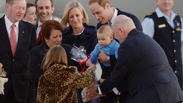 Prince George receives a gift after landing in Canberra.