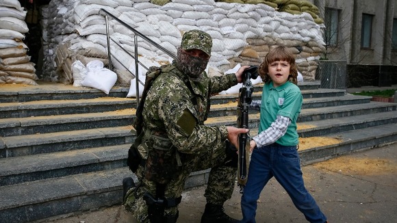 A pro-Russian insurgent poses for a photo with a child in Slaviansk.