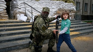 An armed pro-Russian poses for a photo with a child in Slaviansk.