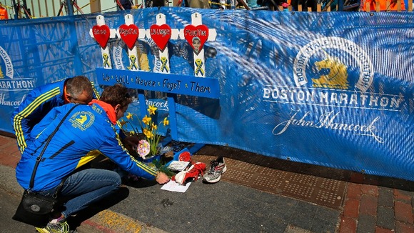 Joel (L) and Jackie Dalton leave mementos for Martin Richard, the youngest victim of last year's bombings.