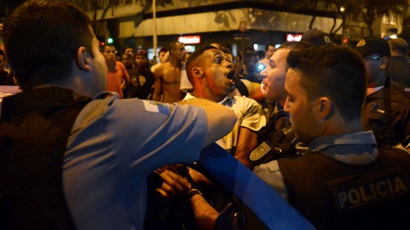 A resident reacts as he is detained by police during the protests.