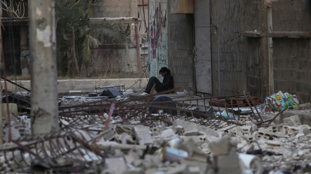 A Syrian rebel fighter rests among debris in Deir al-Zor, eastern Syria.