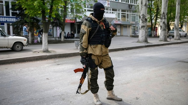 A pro-Russian armed man stands guard near the state security service building in Slaviansk