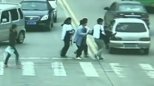 A group of passers-by carry the man off the road