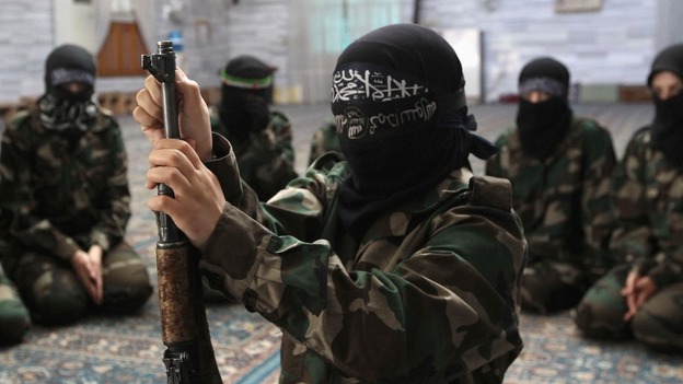 A female rebale fighter assembles a rifle in an Aleppo mosque.
