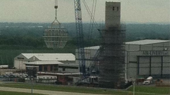 The crane lifts the top cap into position