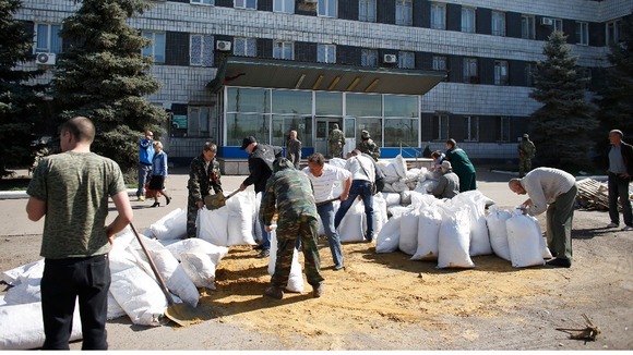 Pro-Russia men build a barricade in front of the seized city council building in Kostyantynivka today.