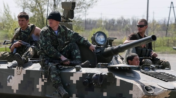 Ukrainian soldiers sit on top of an armoured personnel carrier