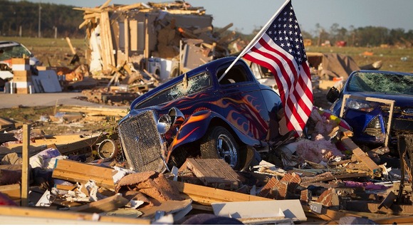A US flag sticks out the window of a damaged hot rod car near near Vilonia, Arkansas.