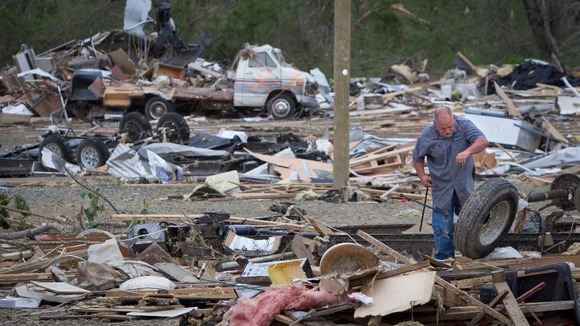 A worker at Mayflower RV retrieves wheels from a trailer destroyed in Mayflower, Arkansas.