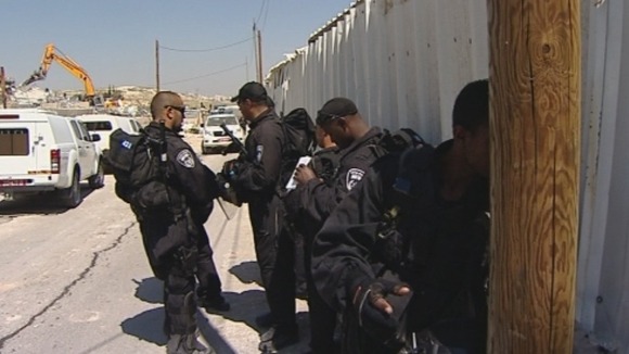 Officers wait nearby as the demolition is underway.