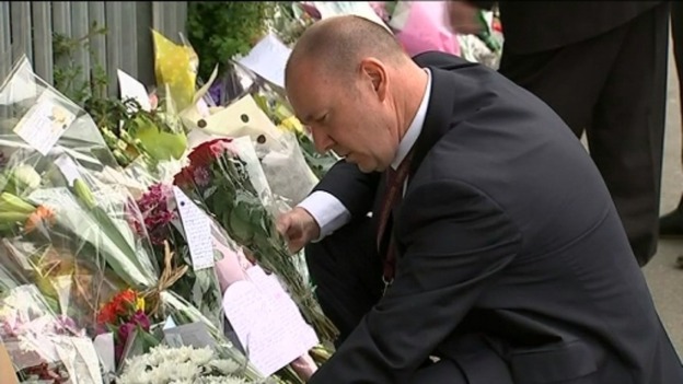 Mr Mort looking at tributes left outside the school