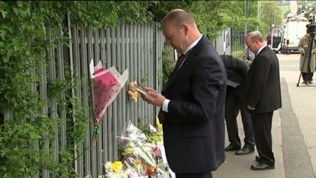 Mr Mort looking at tributes left outside the school
