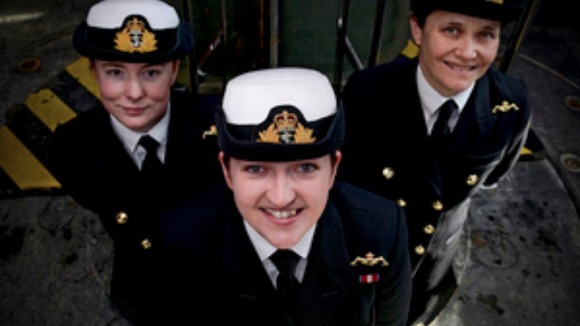 The first three women to become submariners in uniform smiling to camera
