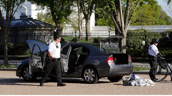 Members of the Uniformed Division of the Secret Service search the car near the White House.