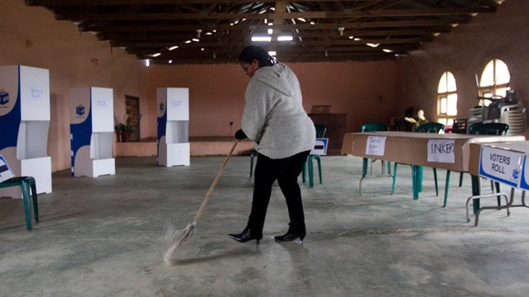 An election official cleans a church that has been transformed into a voting station.