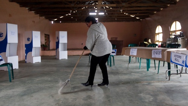An election official cleans a church that has been transformed into a voting station.