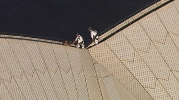 The man was reportedly astride the building for more than an hour.