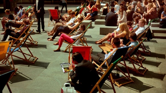 People sun themselves in deckchairs at Regent's Square in London.