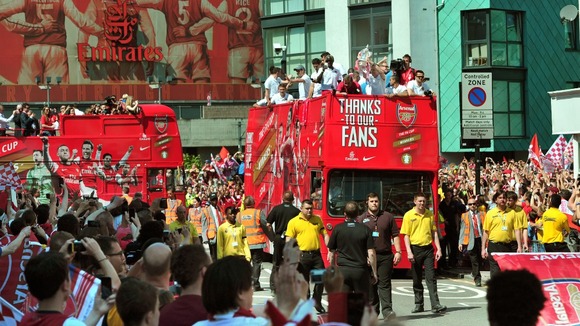 Crowds watch the bus leave the Emirates Stadium.