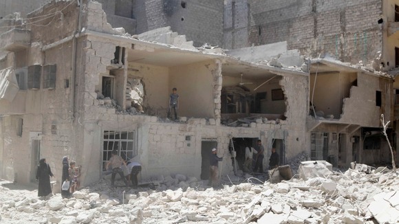 Residents inspect the damage in a destroyed neighbourhood in Aleppo on 18 May