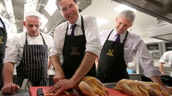 Mr Clegg smiles as he attempts to butcher the bird.