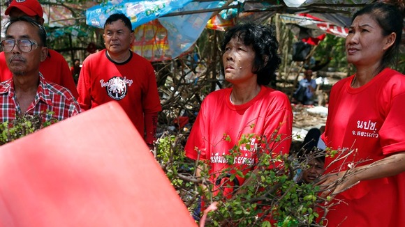 Pro-government "red shirt" supporters listen to their leader's speech inside their encampment in the suburbs of Bangkok today.