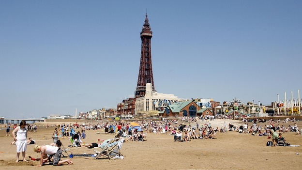 People enjoying the sunshine on the beach below Blackpool Tower