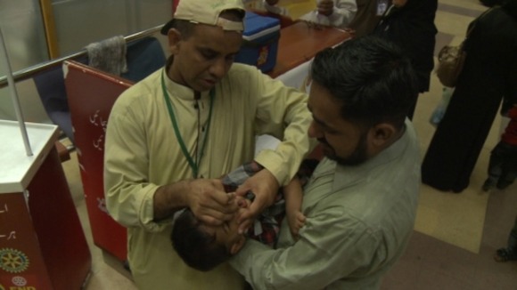 Travelers who cannot prove they have been vaccinated are given polio drops at the airport.