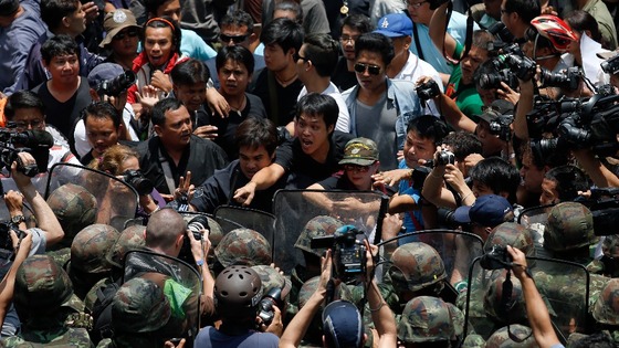 Protesters against military rule and soldiers deployed to control them confront each other at Bangkok's shopping district.